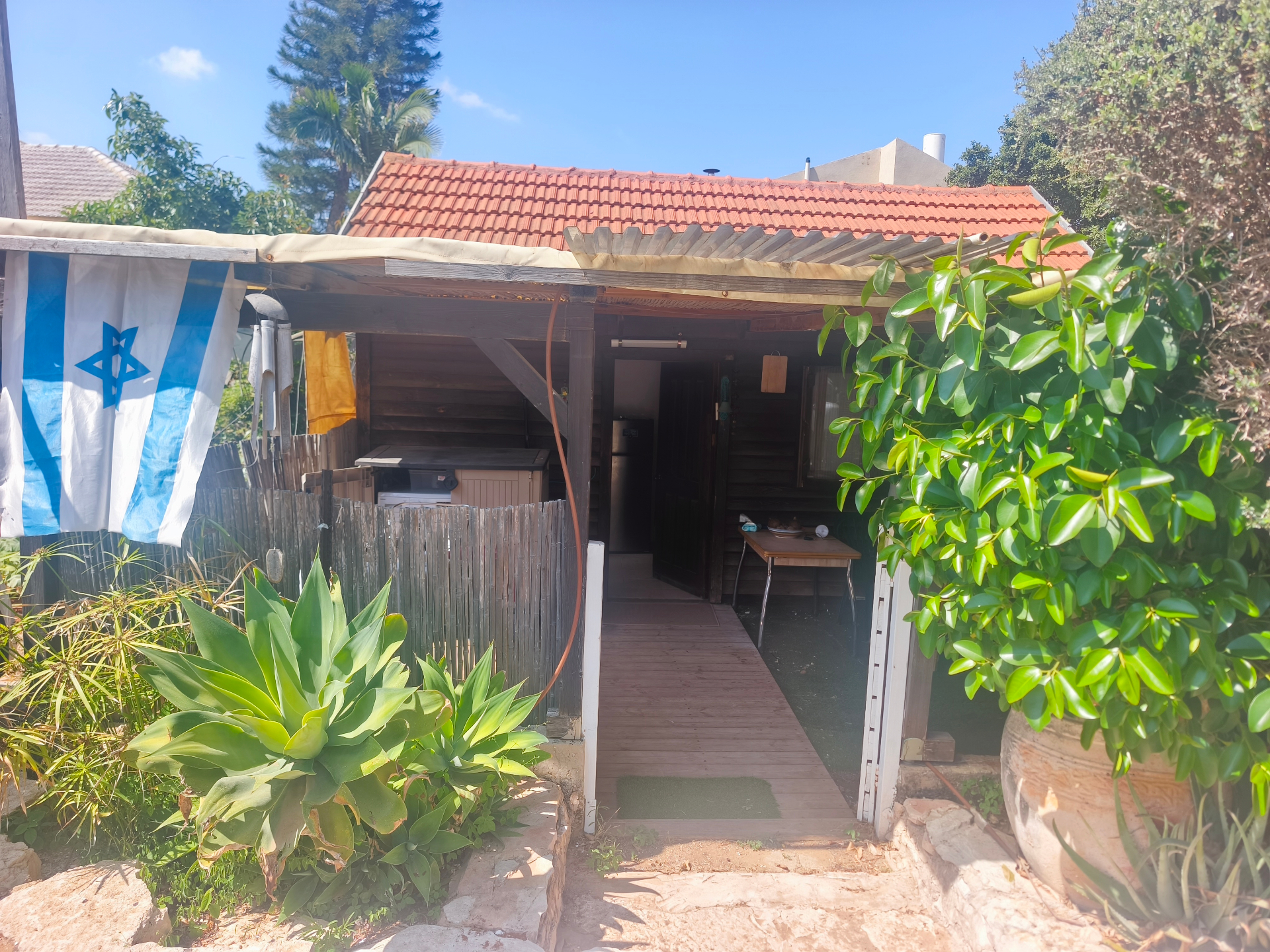 הכניסה לקליניקה בפרדס חנה - מבנה עץ מוקף צמחייה